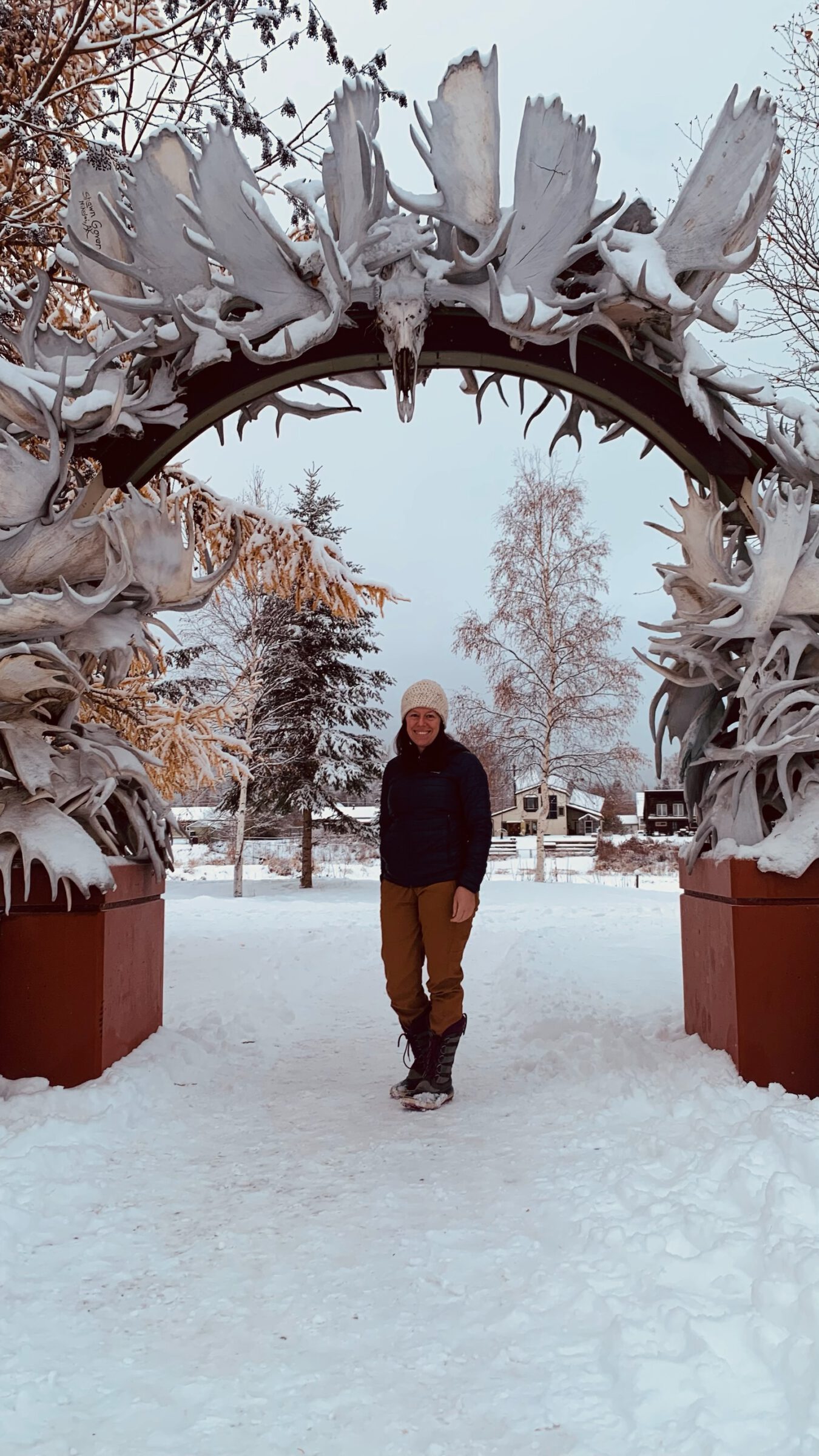 Sarah Lupis, SWCA Lead Environmental Planner standing in front of an entrance sign with animal bones around it. 