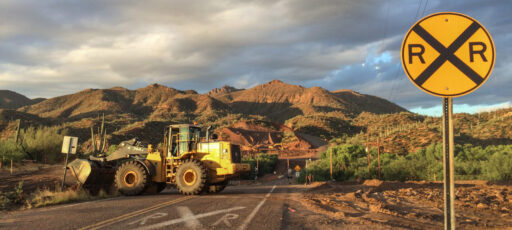A front end loader moves dirt during construction monitoring at Kelvin Bridge, near Kearny, AZ.