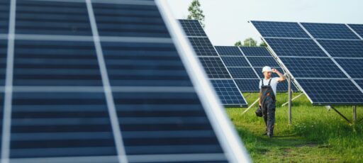 A worker walks through a solar panel farm.