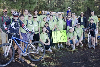 A group of people holding a green sign that says Team SWCA. 