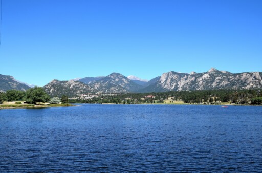 A photo of Lake Estes with trees and a mountain in the back.