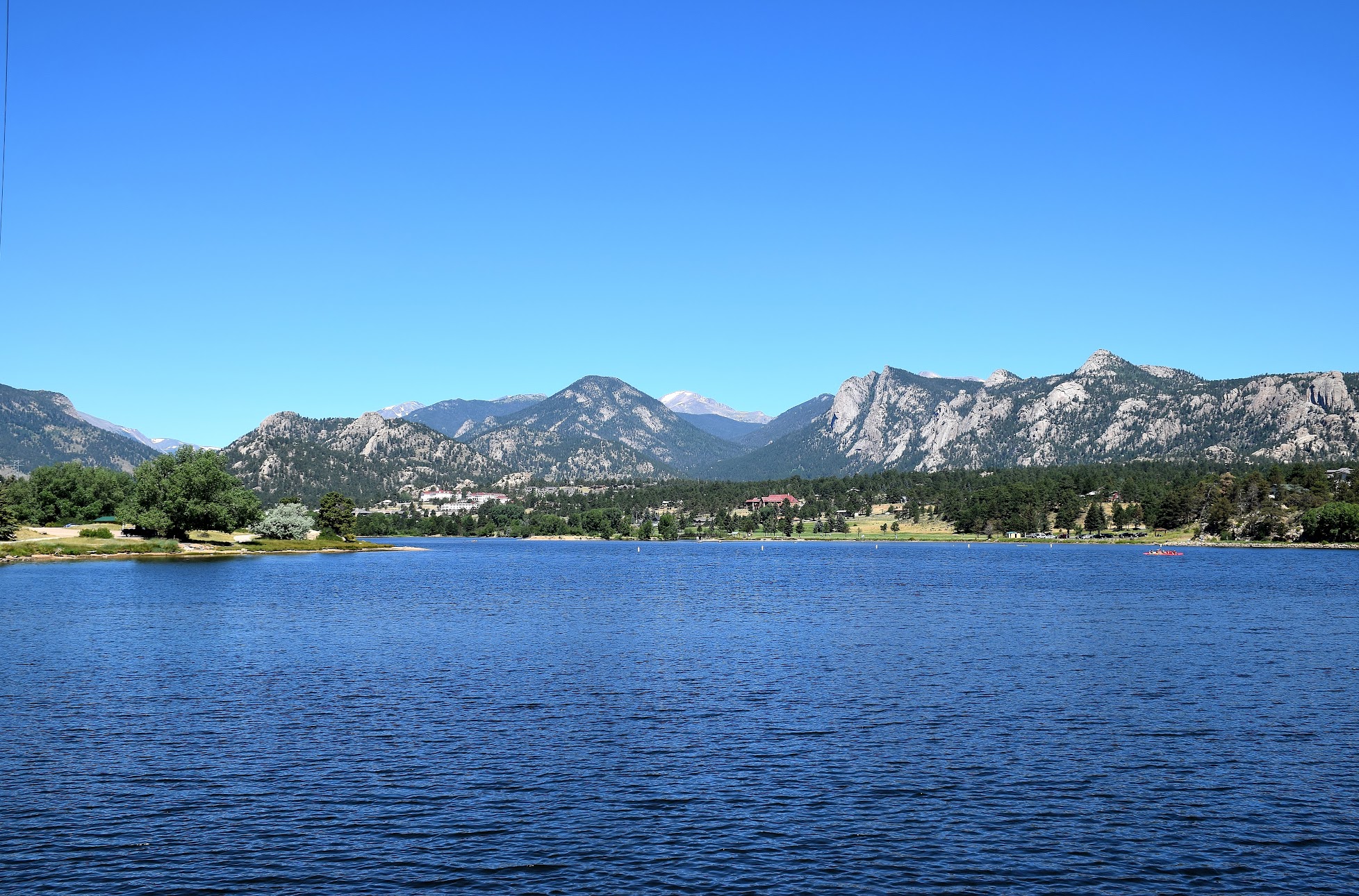 A photo of Lake Estes with trees and a mountain in the back.