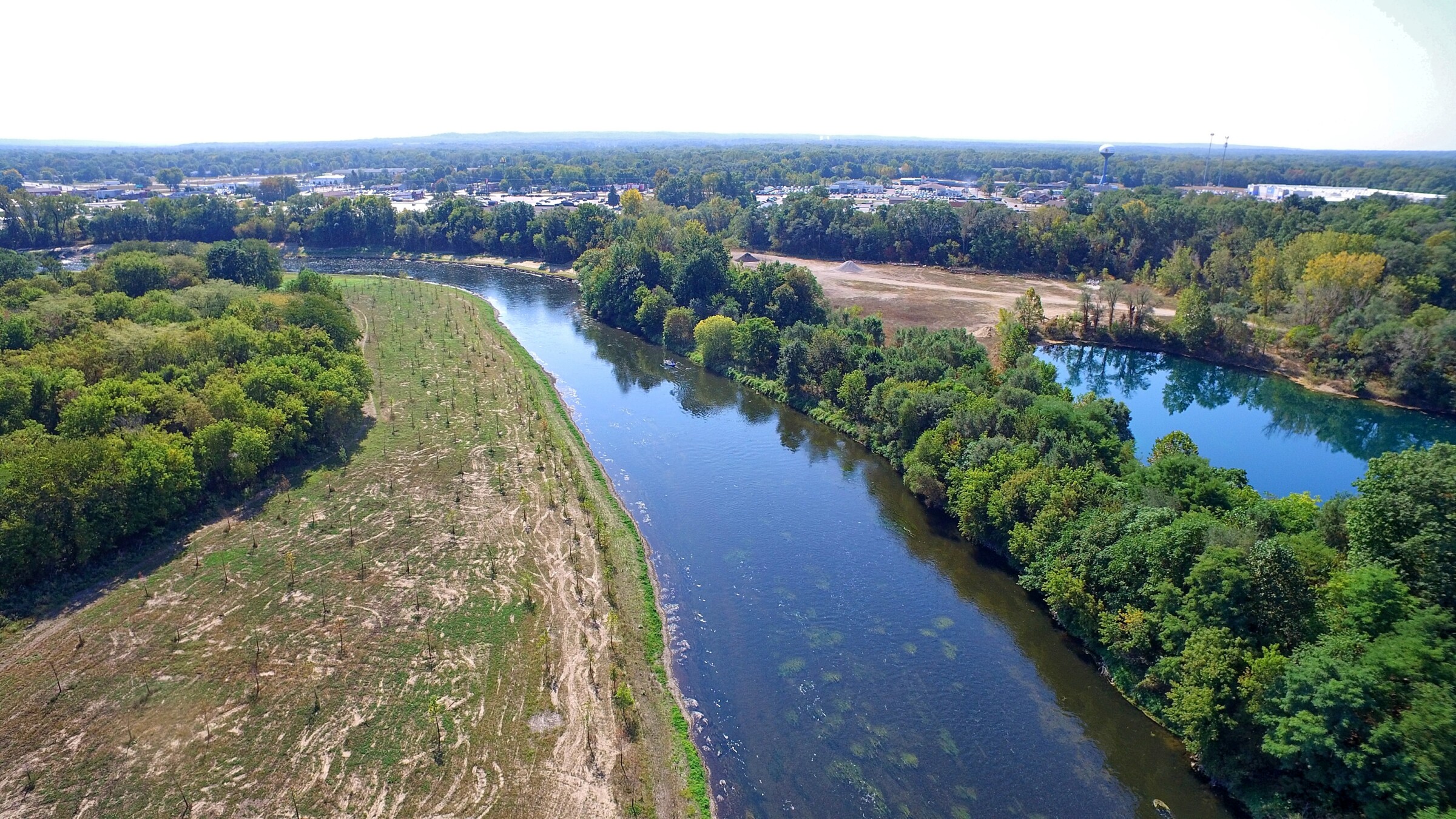 Drone image of Kalamazoo River with trees around the banks.