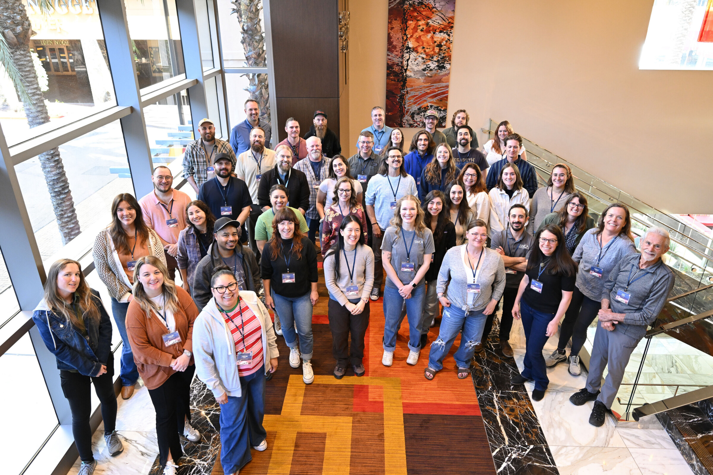 A large group of people posing for a photo in a brightly lit indoor space. 