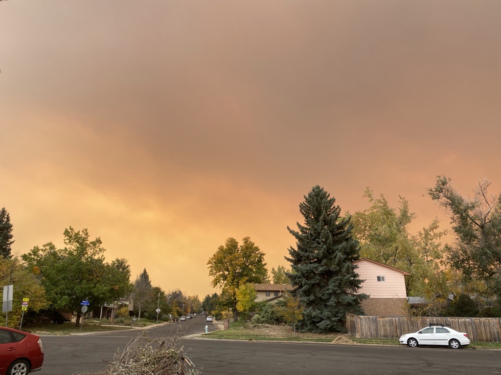 Wildfire smoke is seen in the sky behind a neighborhood. 