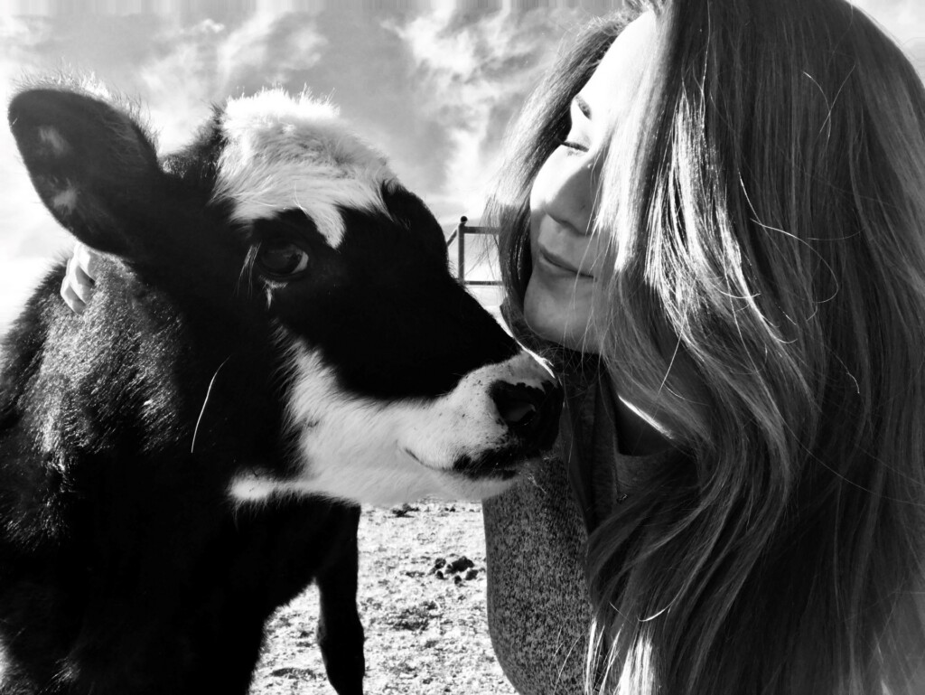 Sydney Lance next to a calf in a black and white photo. 