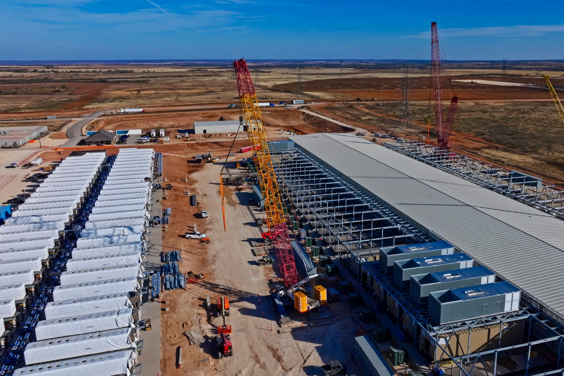 Aerial view of data center construction with BESS batteries and red cranes