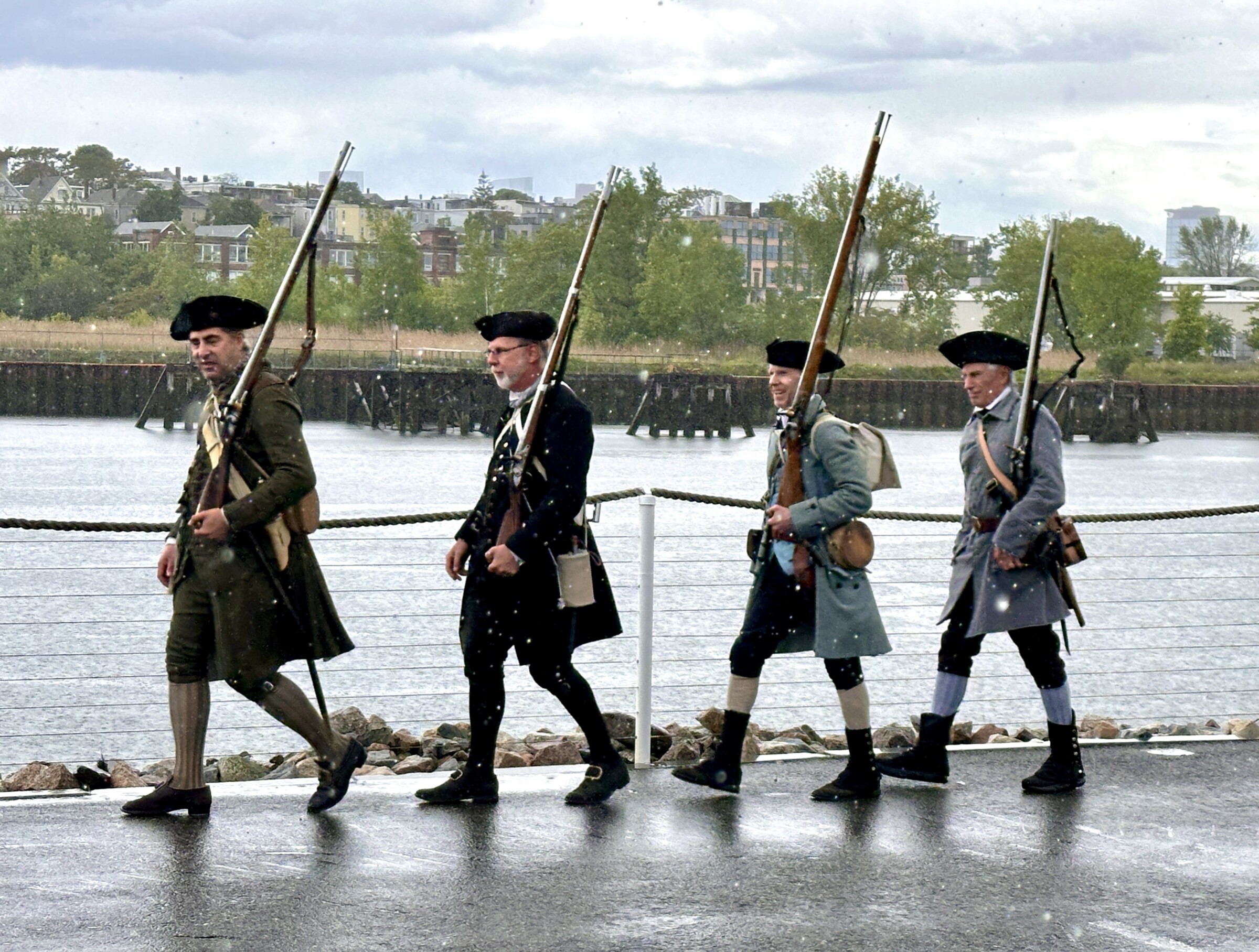 Four people shown with American Revolutionary war era costumes.