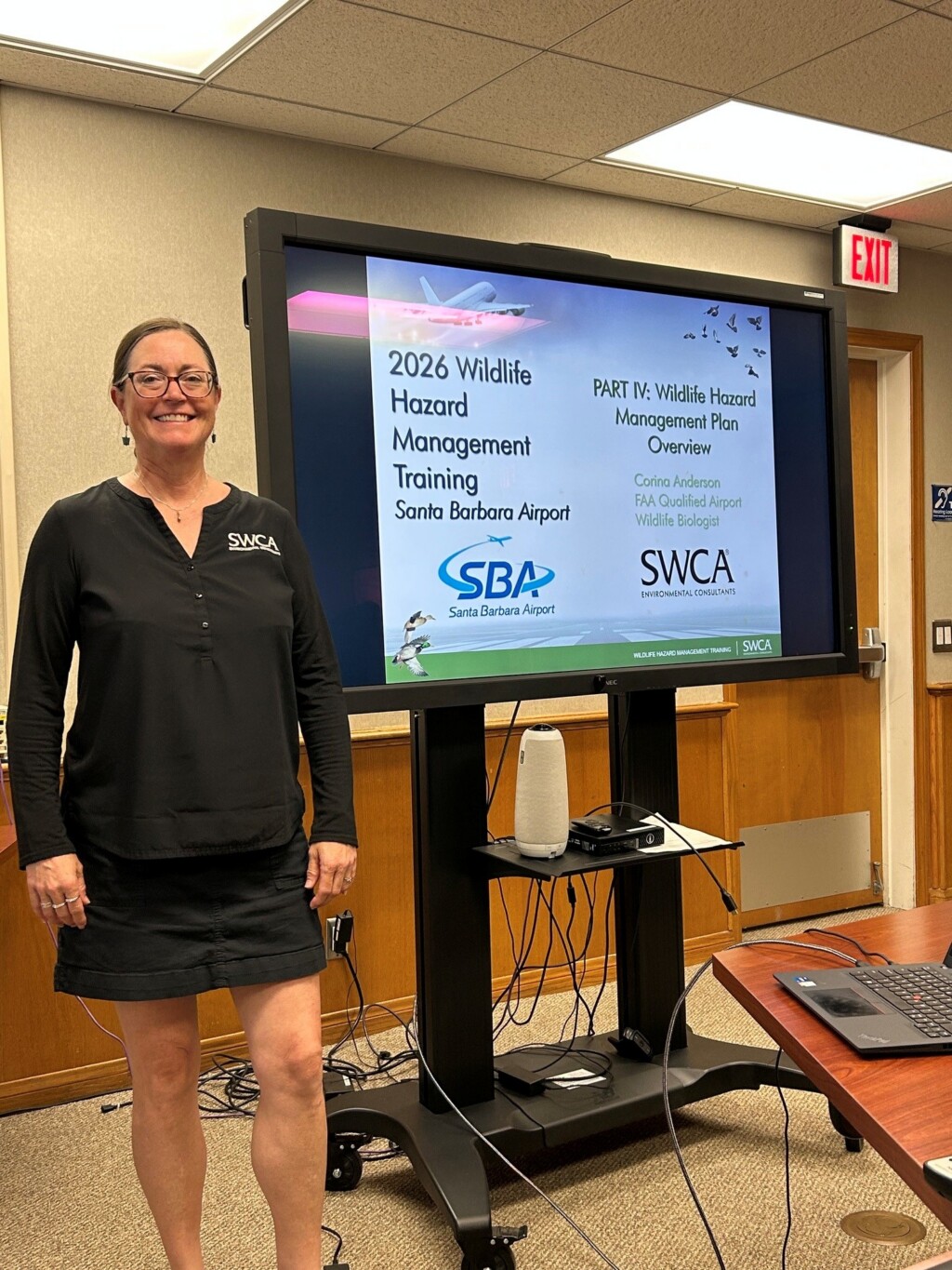 Corina Anderson standing next to a presenting board. 