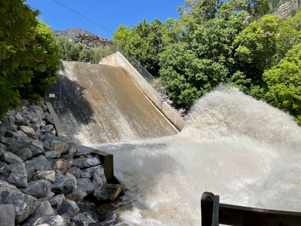 Concrete dam spillway with water rushing down a stepped chute