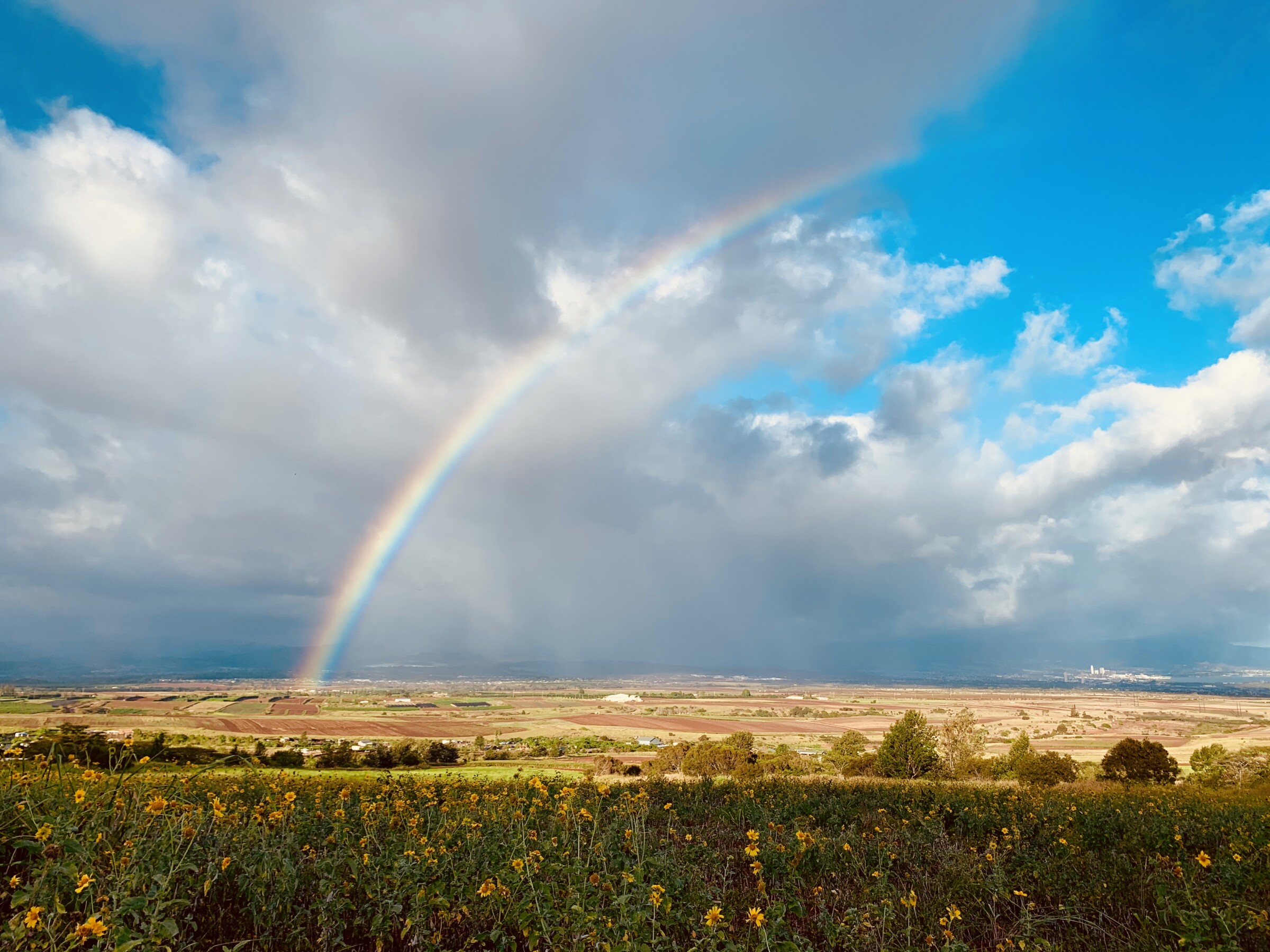 A rainbow arcs over the central plain of Oʻahu, between the Waiʻanae and Koʻolau mountain ranges.